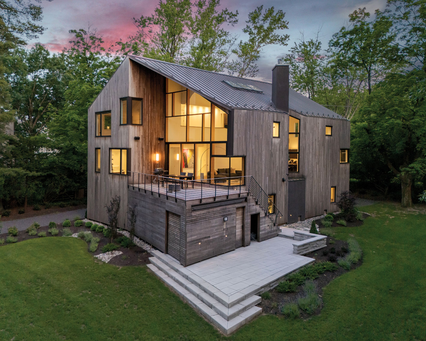 Home exterior with dark gray wood siding and large custom windows